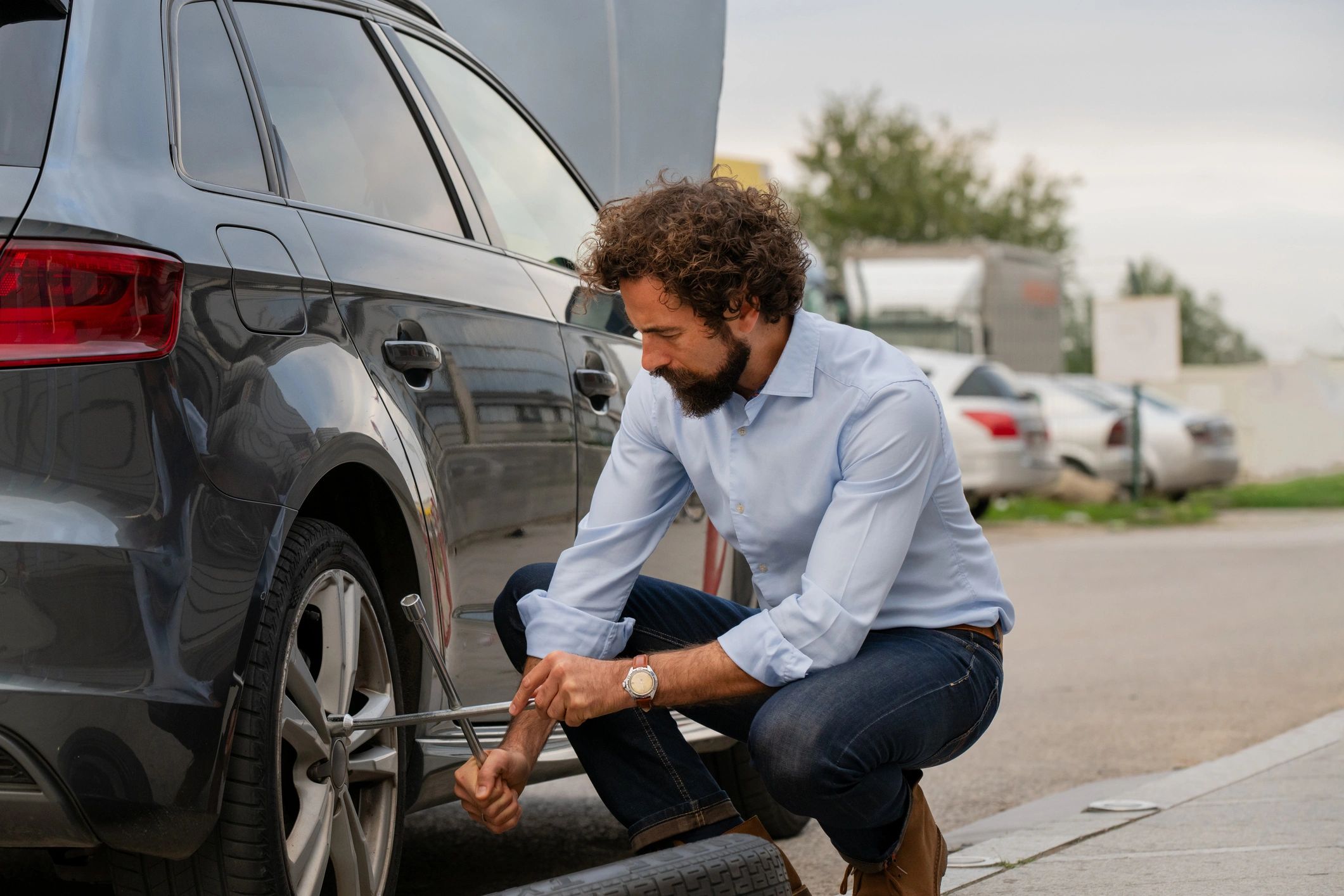 Man Changing Flat Tire on Roadside – DIY Car Maintenance Scene Man Changing Flat Tire on Roadside – DIY Car Maintenance Scene
